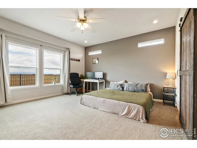 a bedroom with a large bed and a chandelier