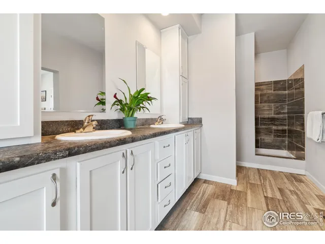 a bathroom with a granite countertop sink a mirror and a potted plant