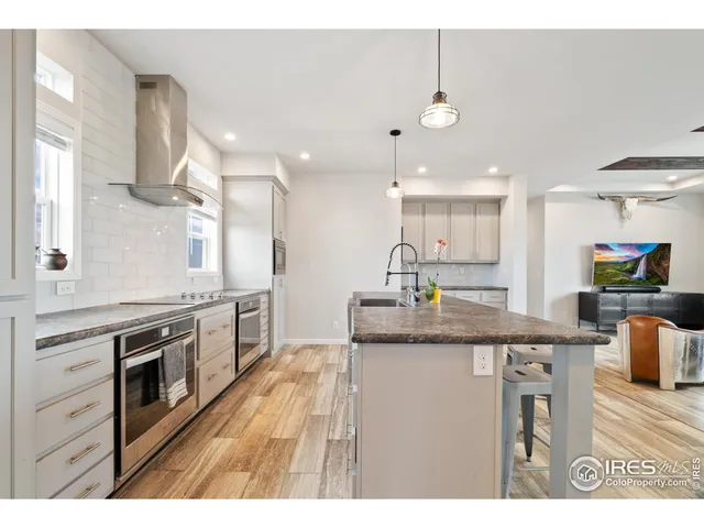 a kitchen with kitchen island granite countertop a sink a counter top space appliances and cabinets