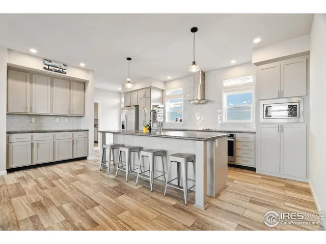a kitchen with kitchen island a white counter space cabinets and stainless steel appliances
