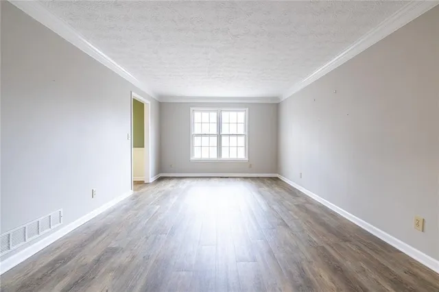 a view of empty room with wooden floor and cabinet