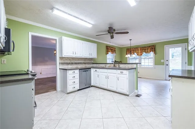 a kitchen with stainless steel appliances granite countertop a sink window and cabinets