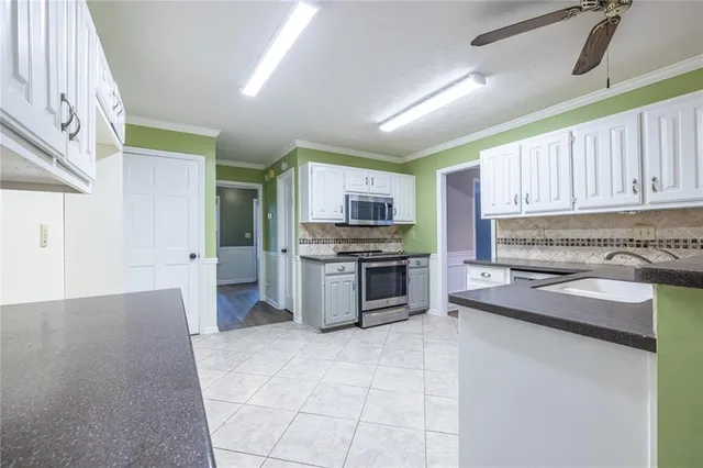 a view of an empty room with window and cabinet area