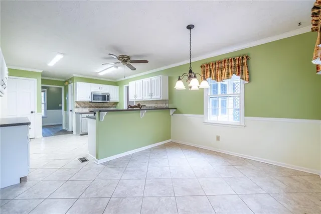 a view of an empty room with wooden floor fireplace and a window