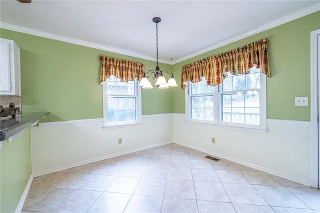 an empty room with windows fireplace and wooden floor