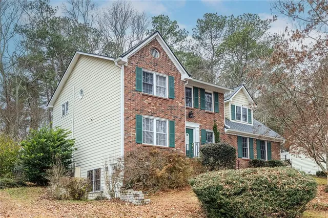 a front view of a house with a yard and potted plants