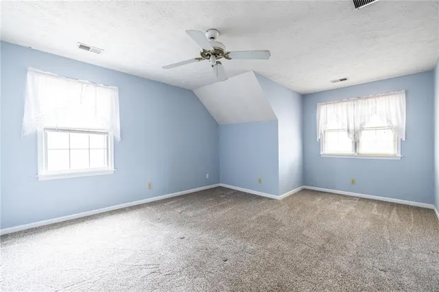 an empty room with a cabinet and mirrors