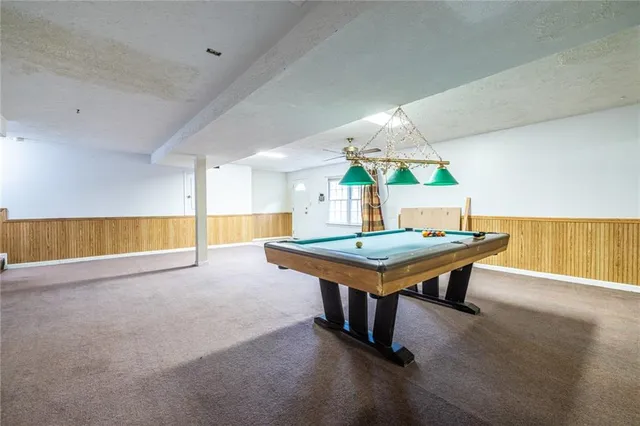 a front view of a house with a yard covered with snow and trees