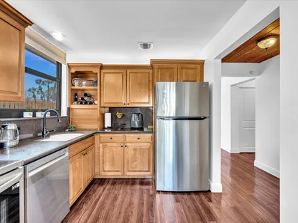 a kitchen with stainless steel appliances a refrigerator sink and wooden floor