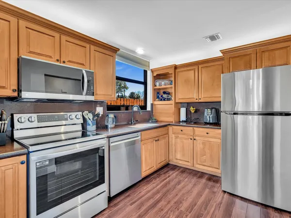 a kitchen with stainless steel appliances a stove microwave and refrigerator