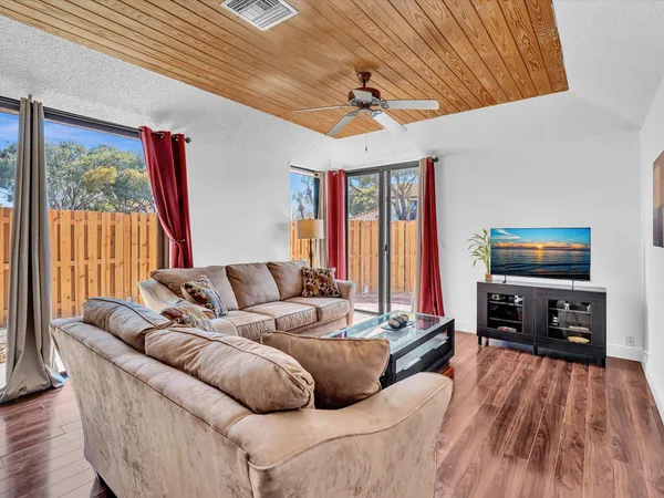 a living room with furniture a flat screen tv and a large window