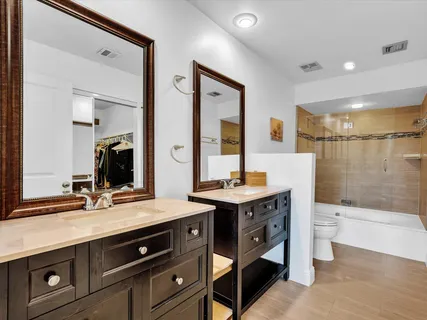 a bathroom with a sink a toilet a mirror and shower