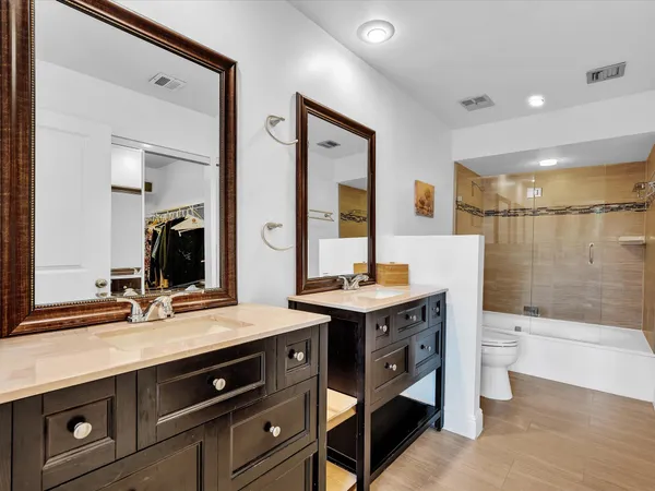 a bathroom with a sink a toilet a mirror and shower
