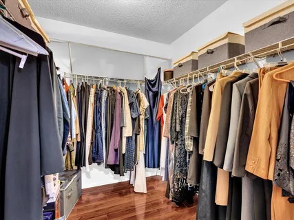 a view of walk in closet with clothes