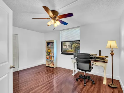a view of a workspace with furniture and a window