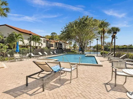 a view of swimming pool with outdoor seating and trees in the background