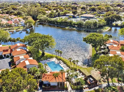 an aerial view of residential houses with outdoor space and lake view