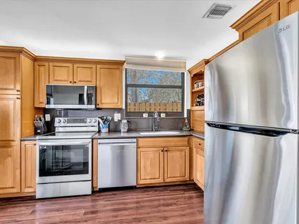 a kitchen with stainless steel appliances a refrigerator sink and microwave