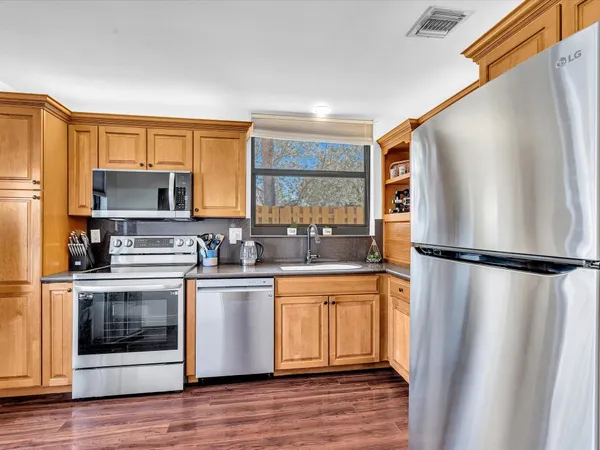 a kitchen with stainless steel appliances a refrigerator sink and microwave