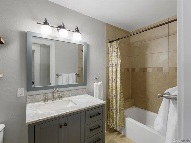 a bathroom with a sink and mirror with bathtub