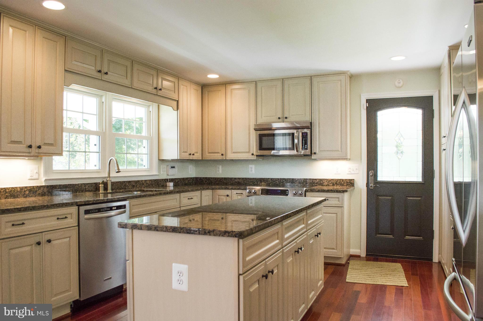 2050 Holland Cliffs Road Huntingtown, MD 20639 - Photo 12 of 29 a kitchen with granite countertop a sink stove and refrigerator