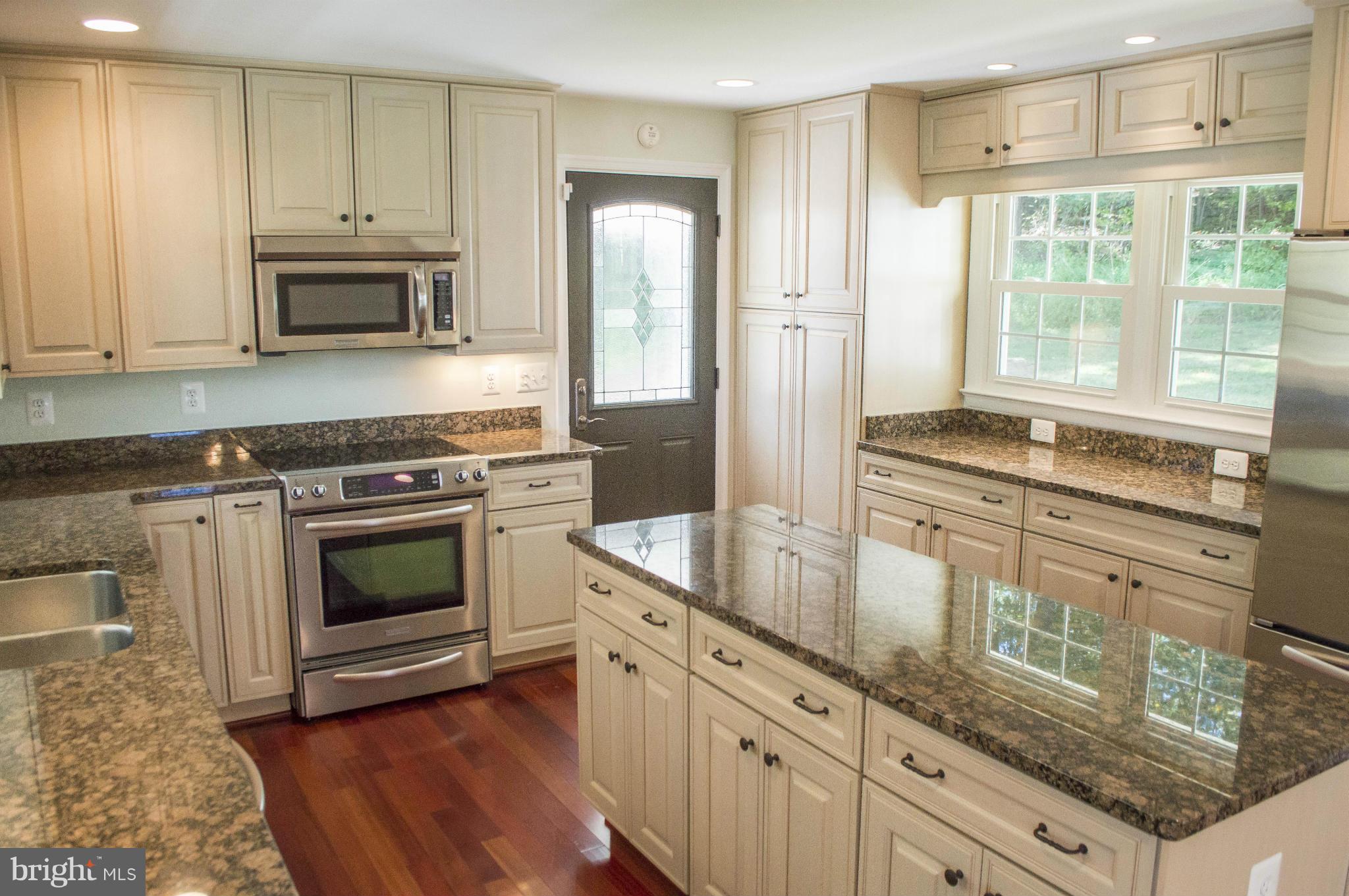 2050 Holland Cliffs Road Huntingtown, MD 20639 - Photo 13 of 29 a kitchen with granite countertop a stove a sink and a refrigerator