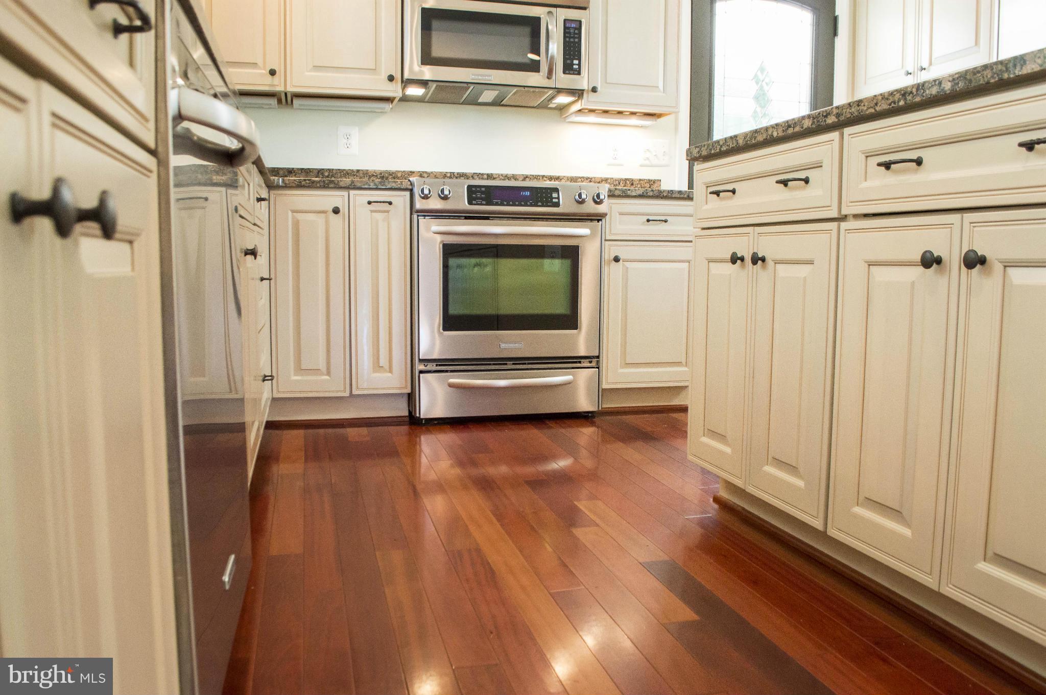 2050 Holland Cliffs Road Huntingtown, MD 20639 - Photo 26 of 29 a view of a kitchen with wooden floor and electronic appliances