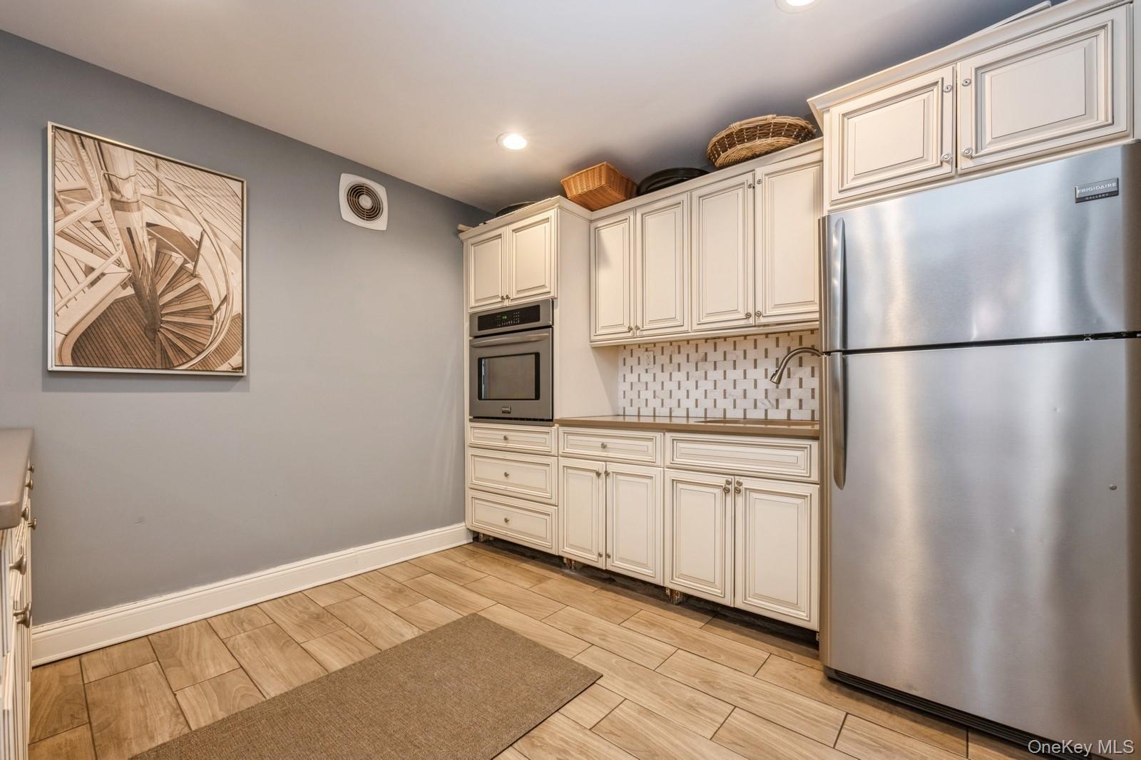 700 Shore Road, Unit 4O Long Beach, NY 11561 - Photo 27 of 42 a kitchen with stainless steel appliances granite countertop a refrigerator sink and cabinets