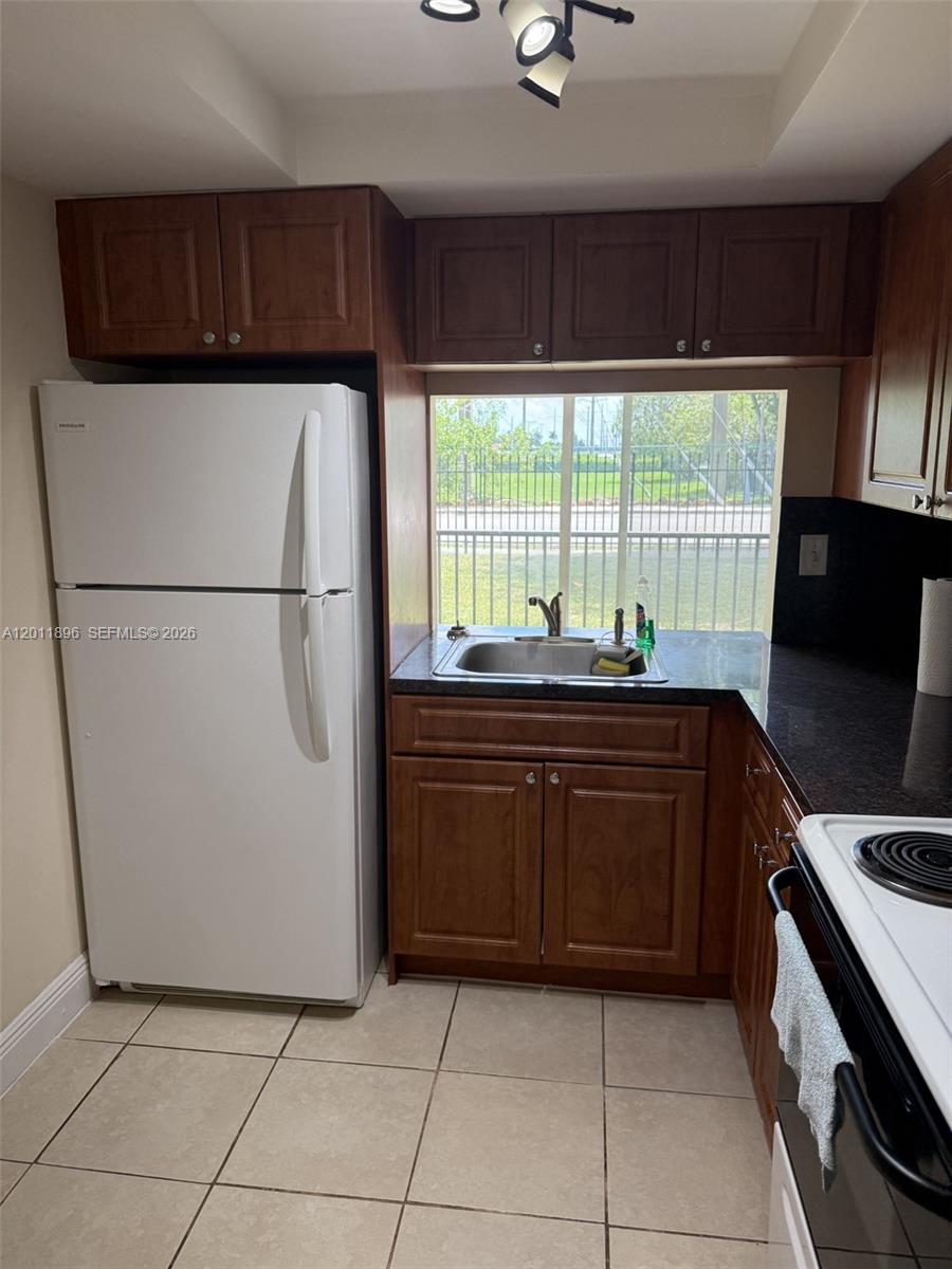 9411 Southwest 4th Street, Unit 111 Miami, FL 33174 - Photo 7 of 20 a kitchen with a refrigerator and a sink