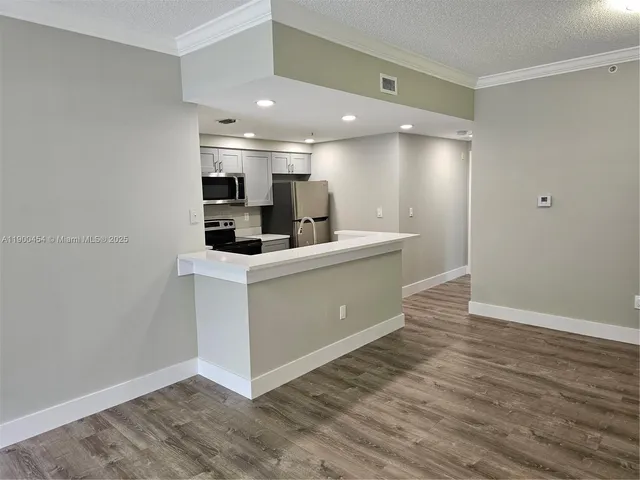 a kitchen with a sink cabinets and wooden floor