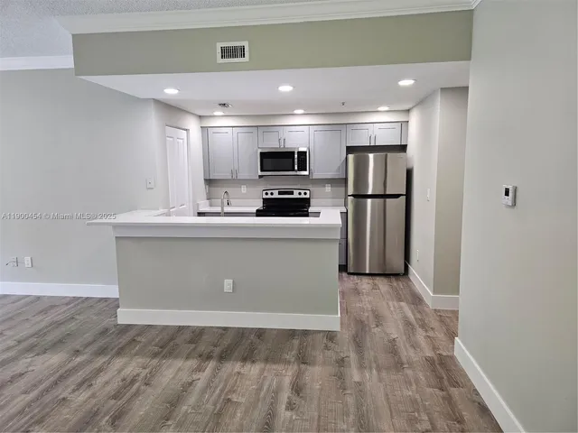 a kitchen with stainless steel appliances a refrigerator sink and microwave