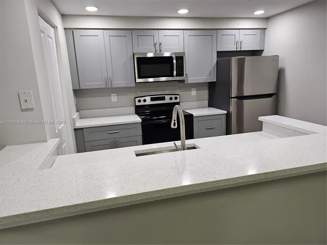 a kitchen with stainless steel appliances a refrigerator and a stove top oven