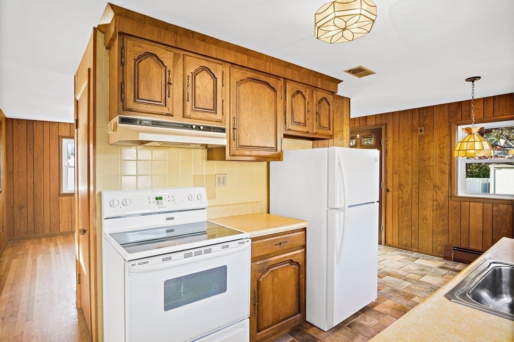 7 Roland Road Peabody, MA 01960 - Photo 7 of 24 a kitchen with stainless steel appliances granite countertop a refrigerator a stove and a cabinets
