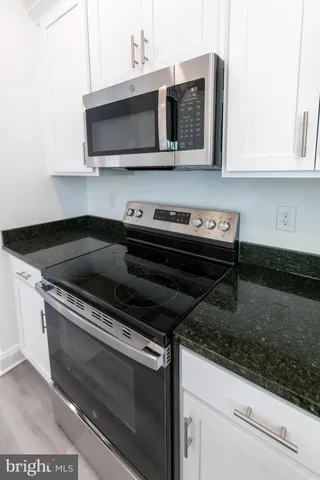 a kitchen with stainless steel appliances granite countertop a stove microwave and oven