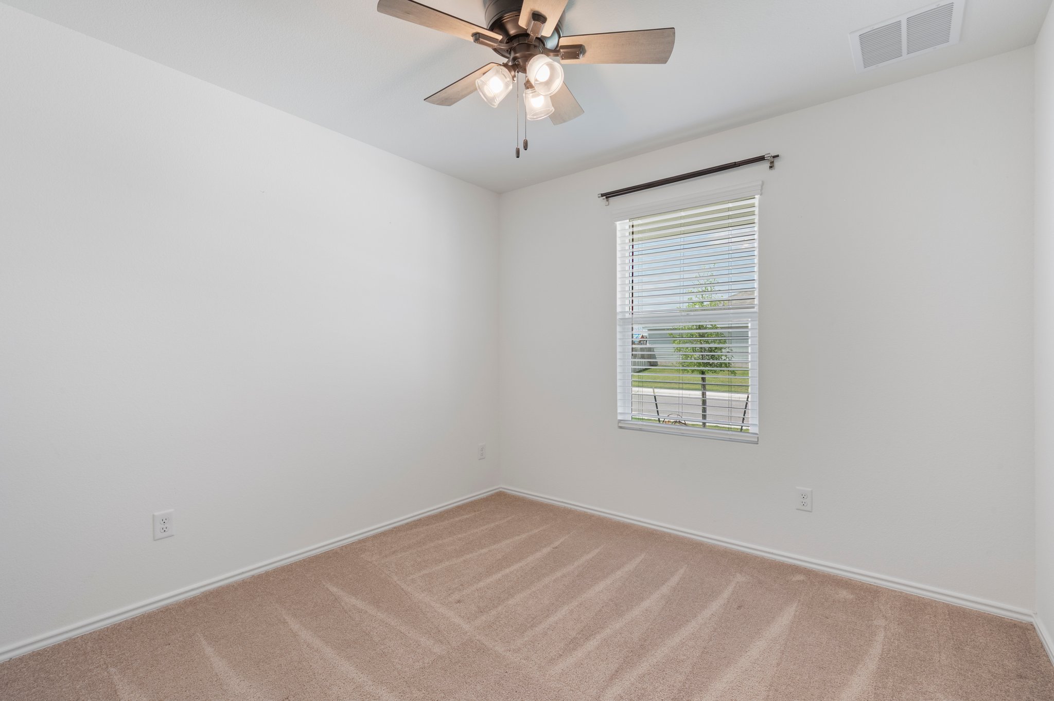 412 Heritage Grvs Road Bertram, TX 78605 - Photo 4 of 15 Light-filled room featuring neutral-toned carpet, white walls, and a window with horizontal blinds