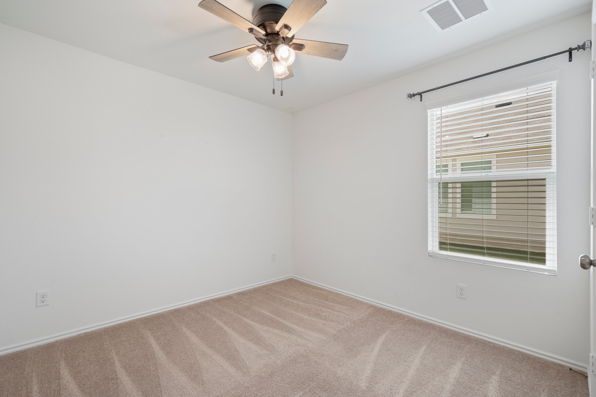 412 Heritage Grvs Road Bertram, TX 78605 - Photo 6 of 15 Carpeted room with a ceiling fan light fixture, baseboard molding, a window featuring blinds, and an overhead air vent
