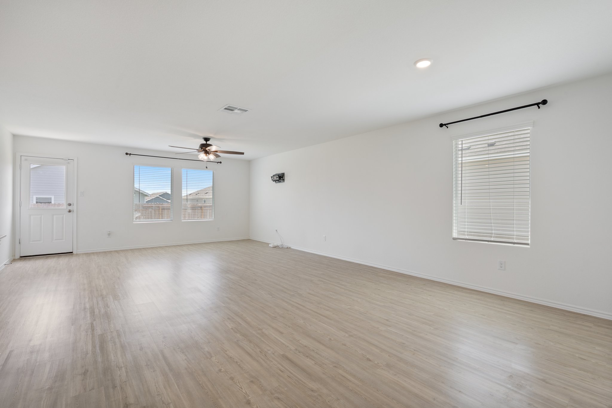 412 Heritage Grvs Road Bertram, TX 78605 - Photo 8 of 15 Expansive room featuring light wood-finish flooring, multiple windows with blinds, a ceiling fan, and recessed lighting