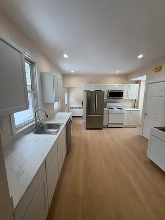 a large kitchen with stainless steel appliances granite countertop a large counter top and a stove top oven