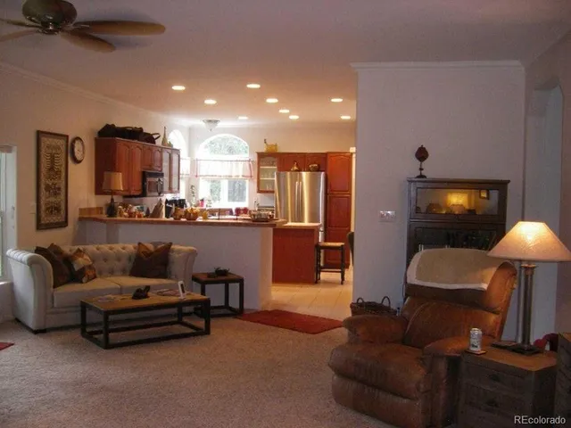 a kitchen with kitchen island a sink appliances a large window and a counter top space