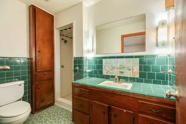 a bathroom with a toilet a sink and shower
