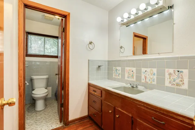 a bathroom with a sink a toilet and a mirror