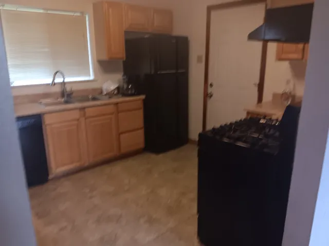 a kitchen with a sink a stove and cabinets