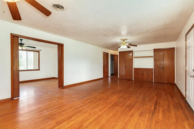a view of an empty room with wooden floor