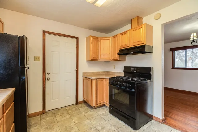 a kitchen with stainless steel appliances granite countertop a stove a refrigerator and a stove top oven