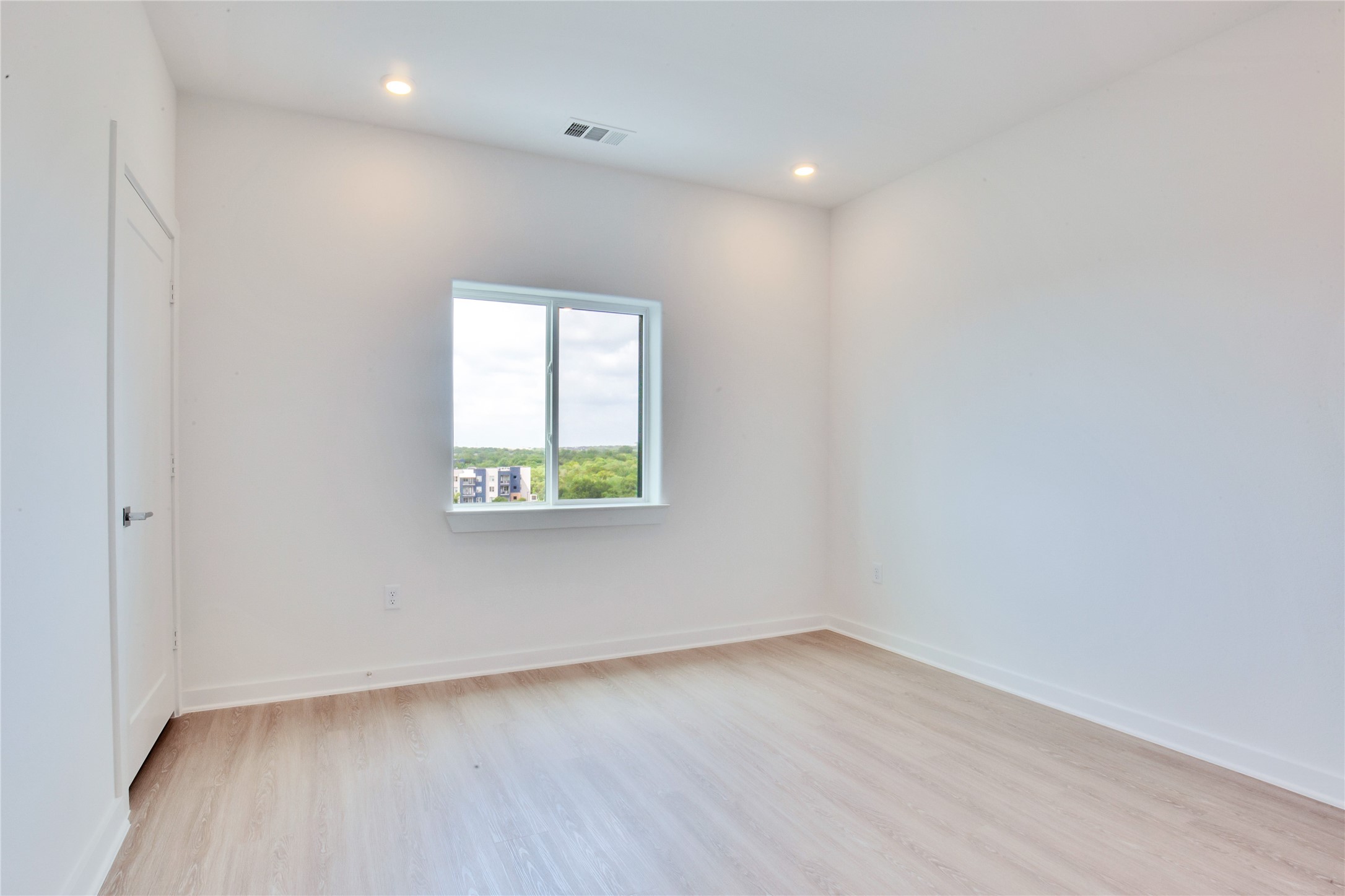 4802 South Congress Avenue, Unit 407 Austin, TX 78745 - Photo 9 of 25 an empty room with wooden floor and window