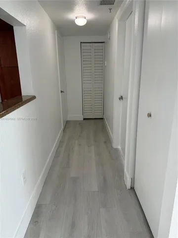a view of a room with wooden floor and entryway