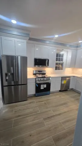 a kitchen with stainless steel appliances a refrigerator and a stove top oven