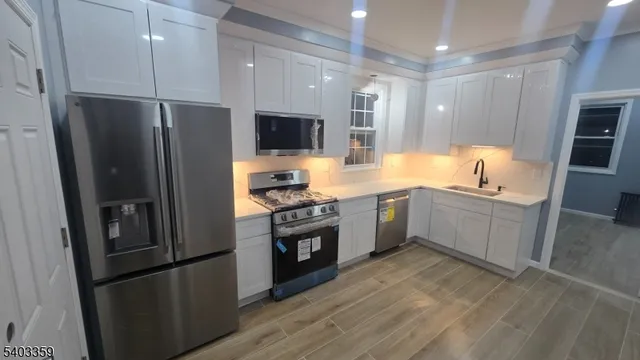 a kitchen with stainless steel appliances a refrigerator sink and microwave