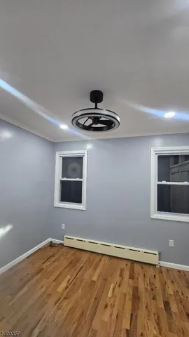 a view of an empty room with wooden floor