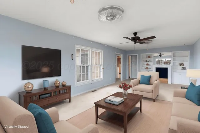 a living room with furniture a flat screen tv and a window